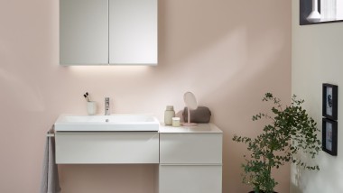 Umývací priestor s kúpeľňovým nábytkom, umývadlom a zrkadlovou skrinkou od spoločnosti Geberit pred pastelovou stenou