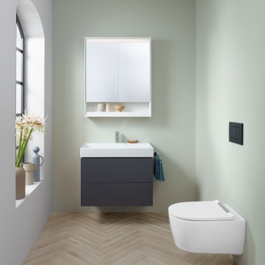 Mała łazienka w kolorze mięty z szafką z umywalką lawową, szafką z lustrem, przyciskiem uruchamiającym i urządzeniami ceramicznymi firmy Geberit